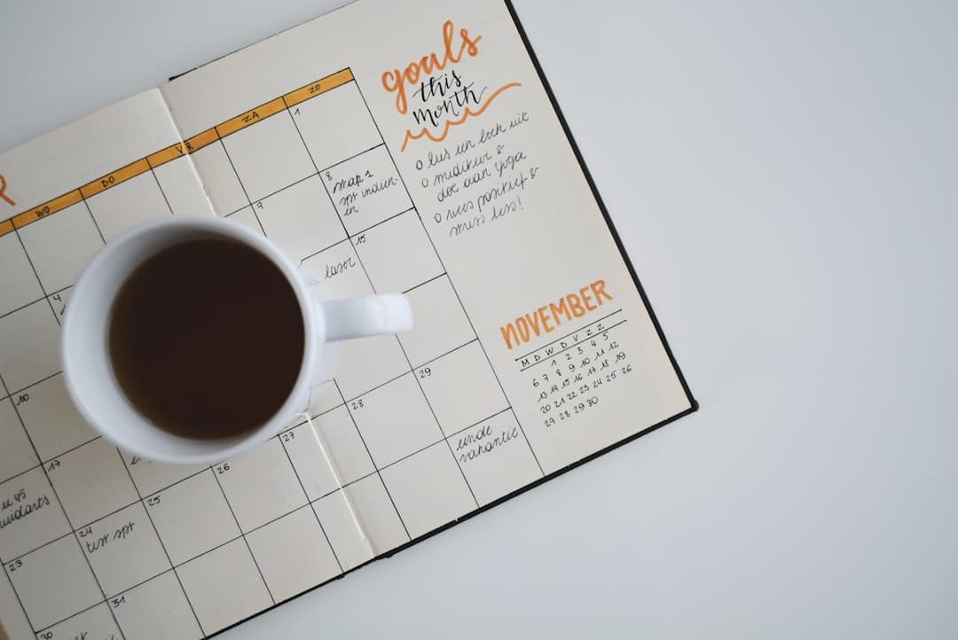 An open planner and a cup of coffee used for mapping out a monthly content calendar