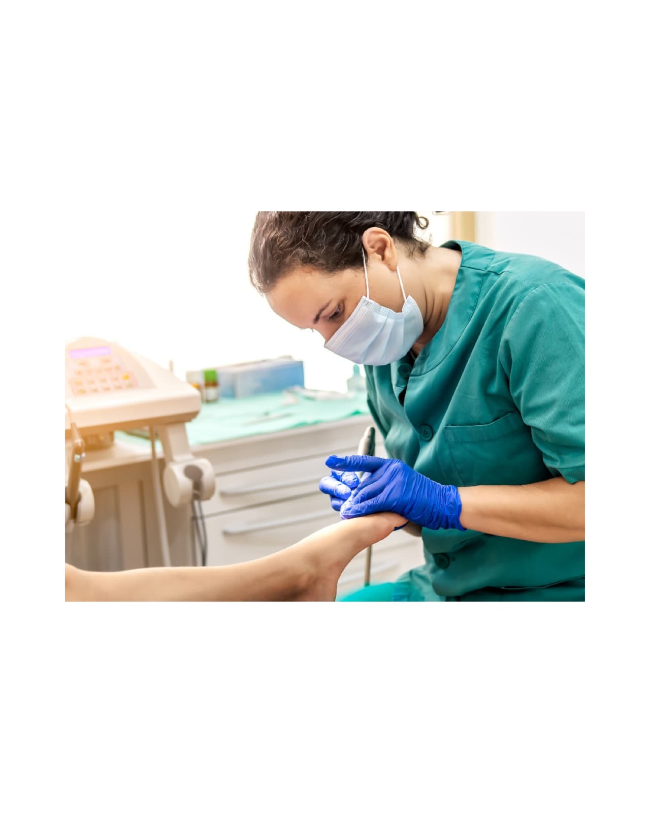 A podiatrist treating a patient's foot in a clinical setting