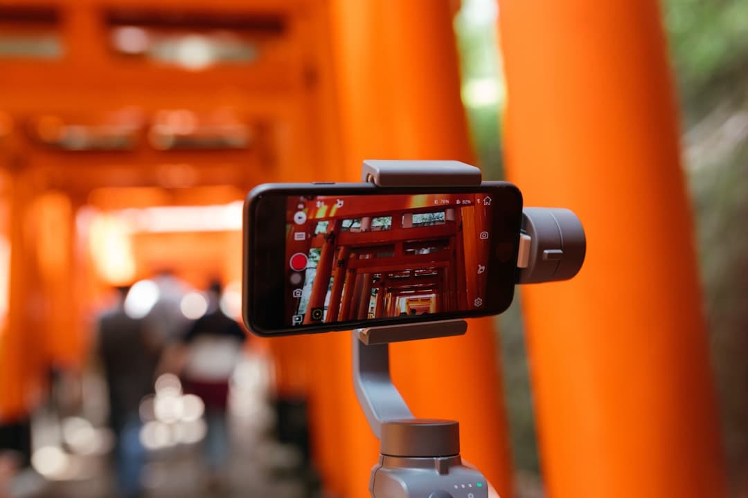 A smartphone mounted on a handheld gimbal recording video